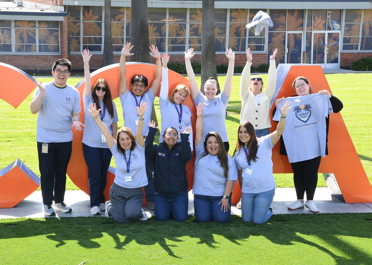 Caring Campus team standing in front of the Go Coast monument sign