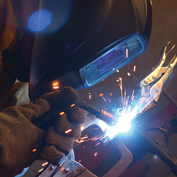 Student using a torch to weld