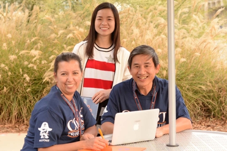 3 ELL students posing for a photo at a table