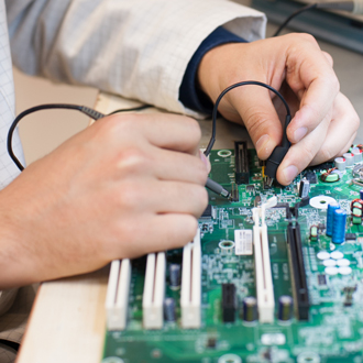 Electronics engineering technician works on a motherboard