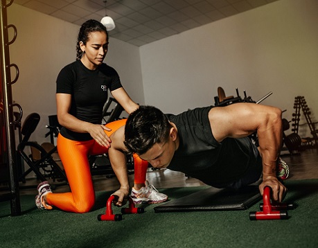 Female fitness coach training client