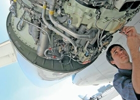 Maintenance worker works on engine of plane