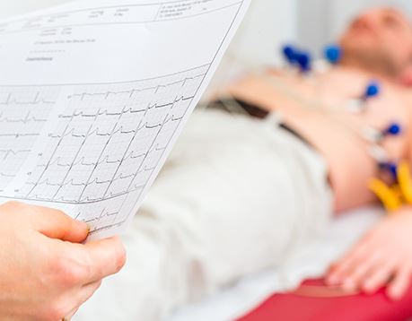 Close-up of printed EKG report with patient blurred in background