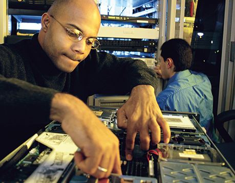 Male network technician works on computer motherboard