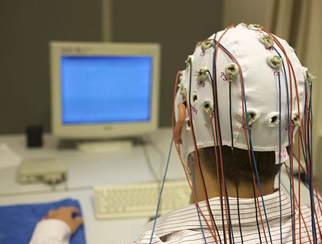 Close-up of a male wearing an EEG brain monitoring cap with electrodes attached