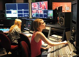 Female students works in a control room of a production studio