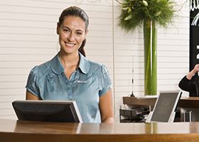 Female front desk manager in green shirt smiles
