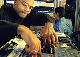 Male network technician works on computer motherboard