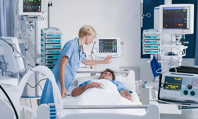 Polysomnographic technologist checks in on a sleeping patient who is monitored by medical equipment