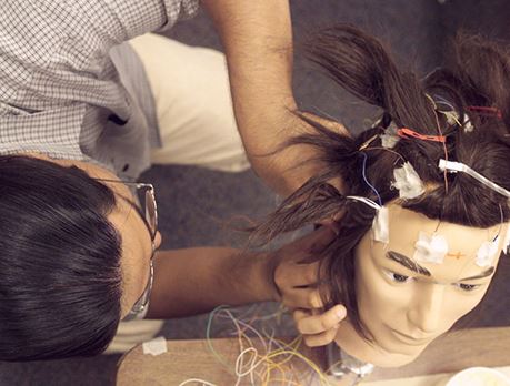A student places electrodes on a training-manikin head