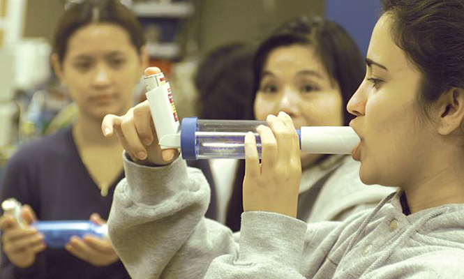 Respiratory care students practice using oxygen inhalers