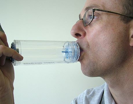 Male patient uses oxygen inhaler