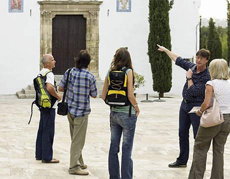 A group on a tour stands outside of a historic-looking building