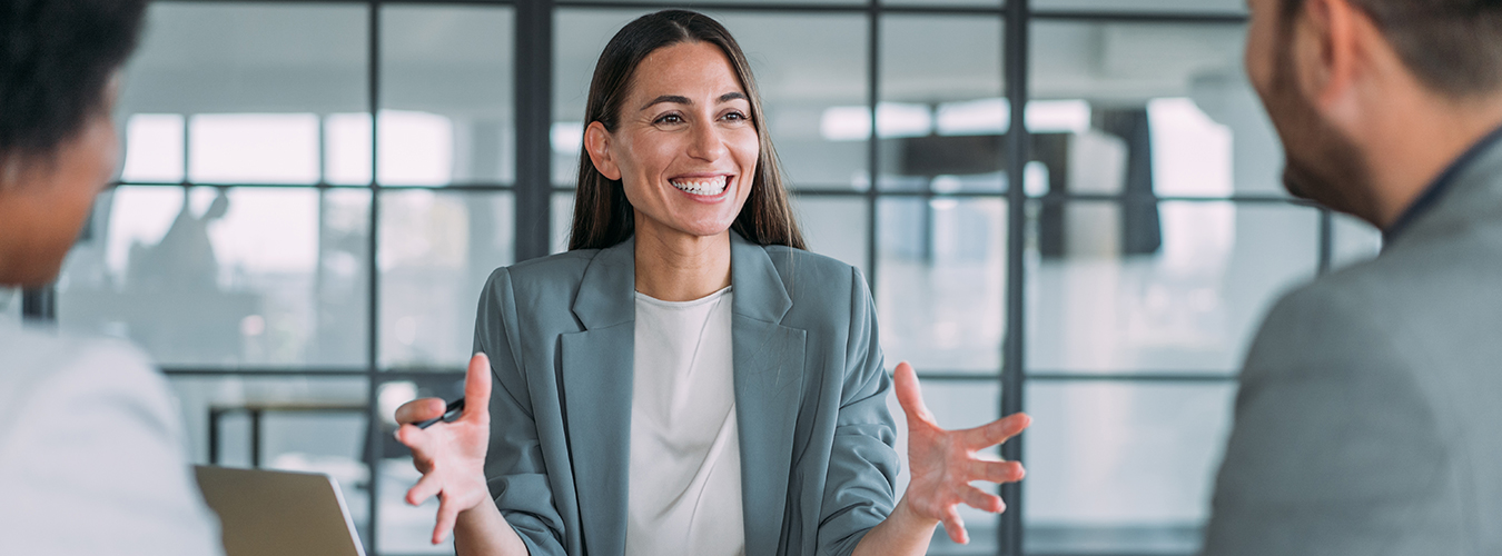 A woman talking to two coworkers.