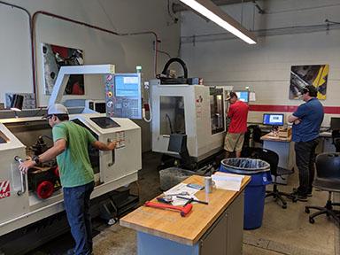 Students working on both Haas CNC lathe and mills.