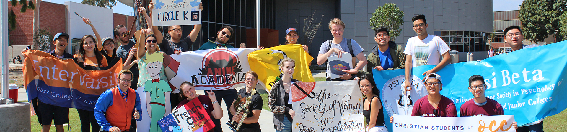 A group of students from various student clubs holding banners