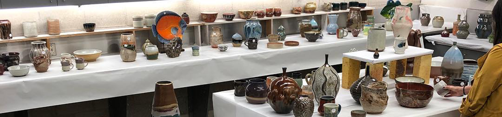 ceramic cups, plates, bowls, vases on tables for ceramics sale