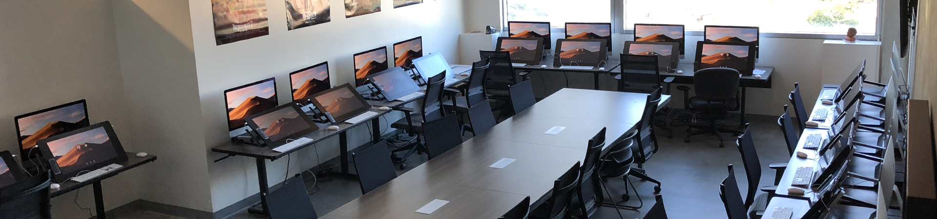 Studio room with tables, chairs, and computers for students to work
