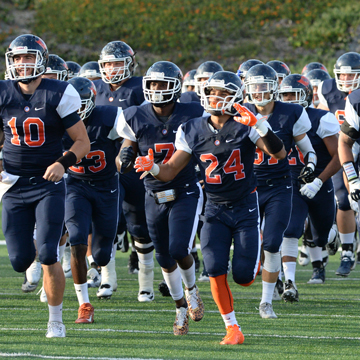 Football team running  together on the field.