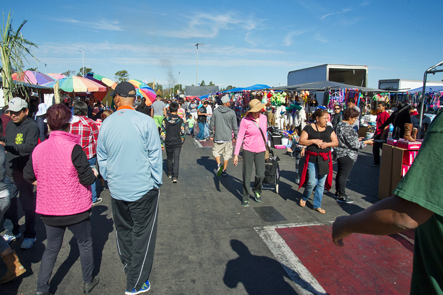 A crowd of people walking through the swap meet