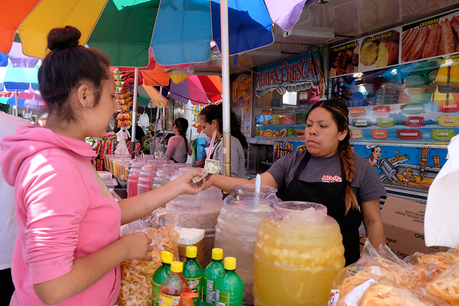 A visitor purchasing food and exchanging money.
