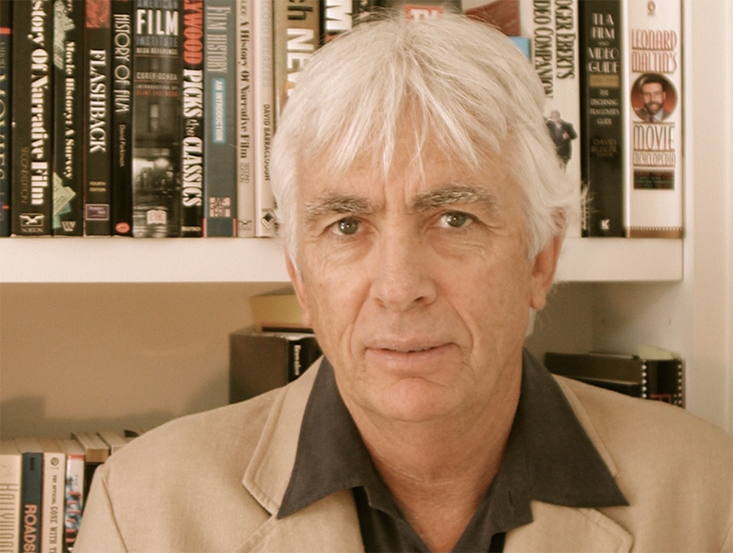 close up image of brian lewis in front of bookshelves