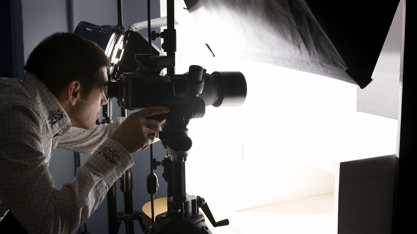 photographer in studio looking through camera