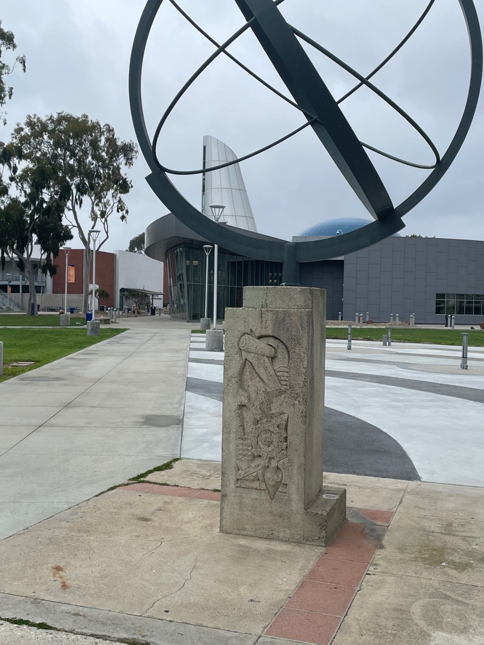 A globe sculpture on a sturdy concrete base