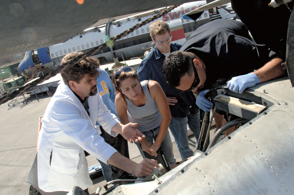 a group of people looking at a plane engine