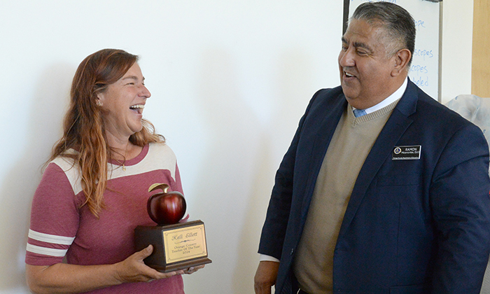 Kelli Elliot holding award next to OCDE Deputy Superintendent Miramontes.