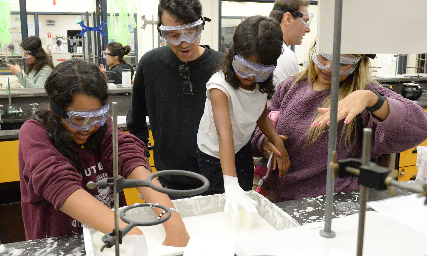 a group of people wearing safety goggles and standing in a lab