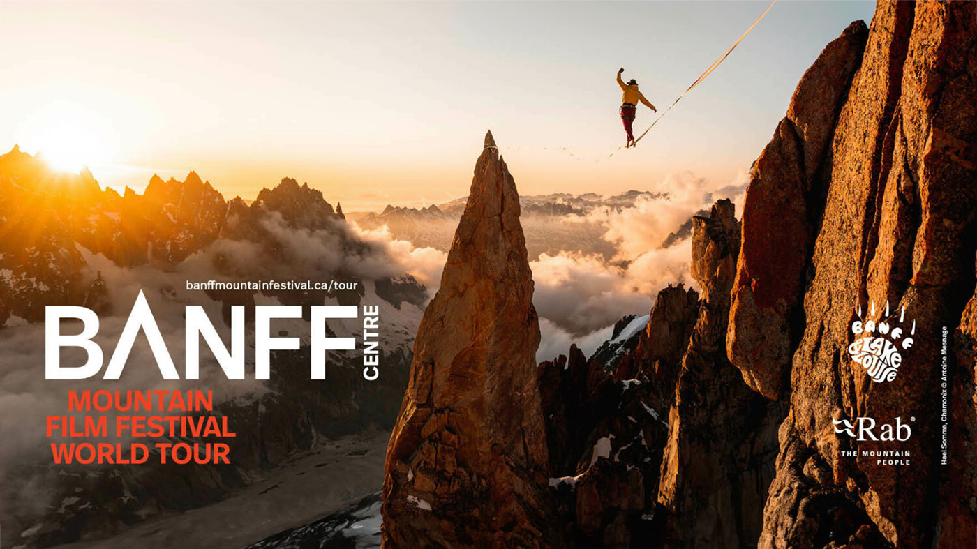 Person walking on tightrope over scenic mountains