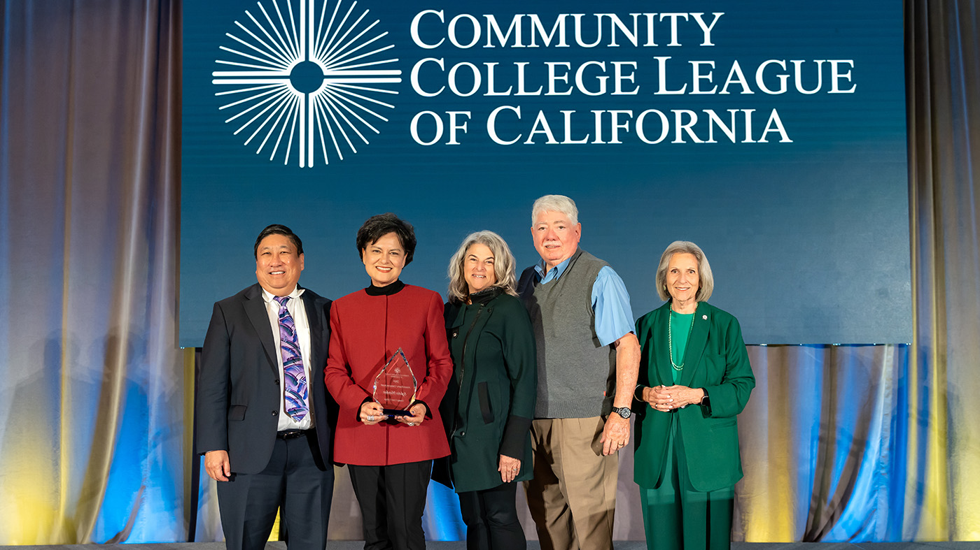 Group of people standing on a stage with a person holding an award