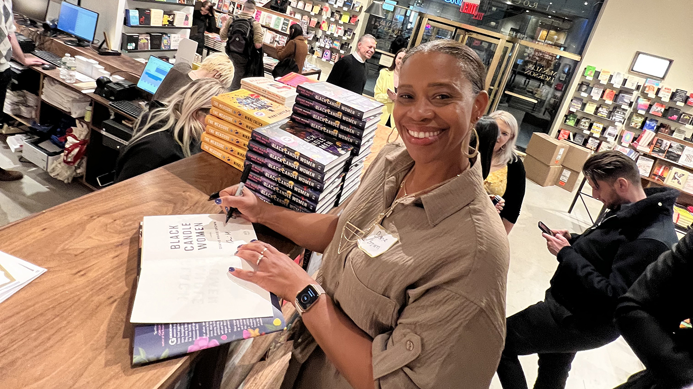 a person smiling at a book signing