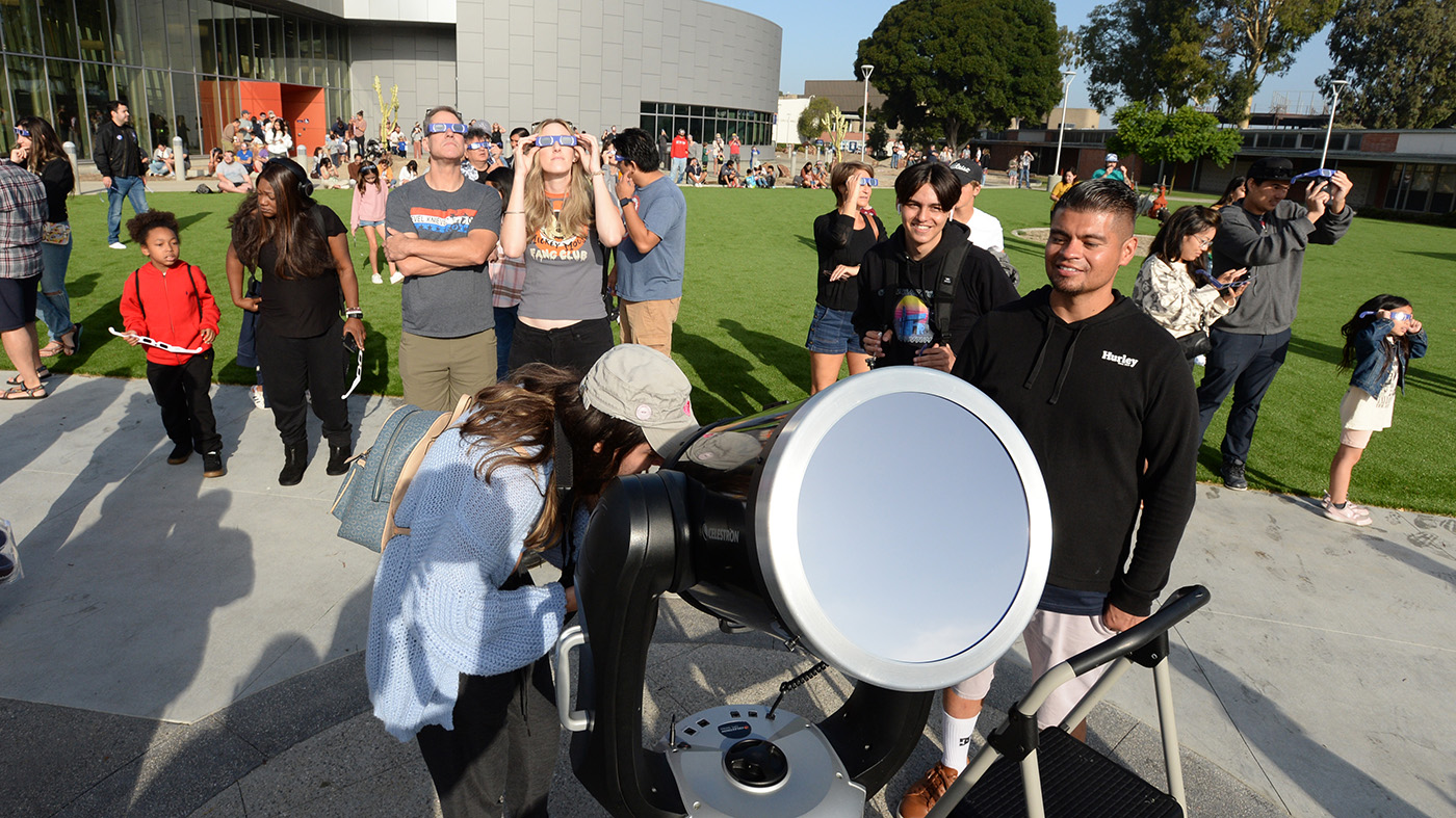 a group of people looking through a telescope