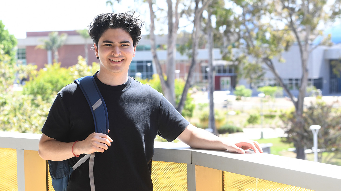 Male smiling and wearing backpack