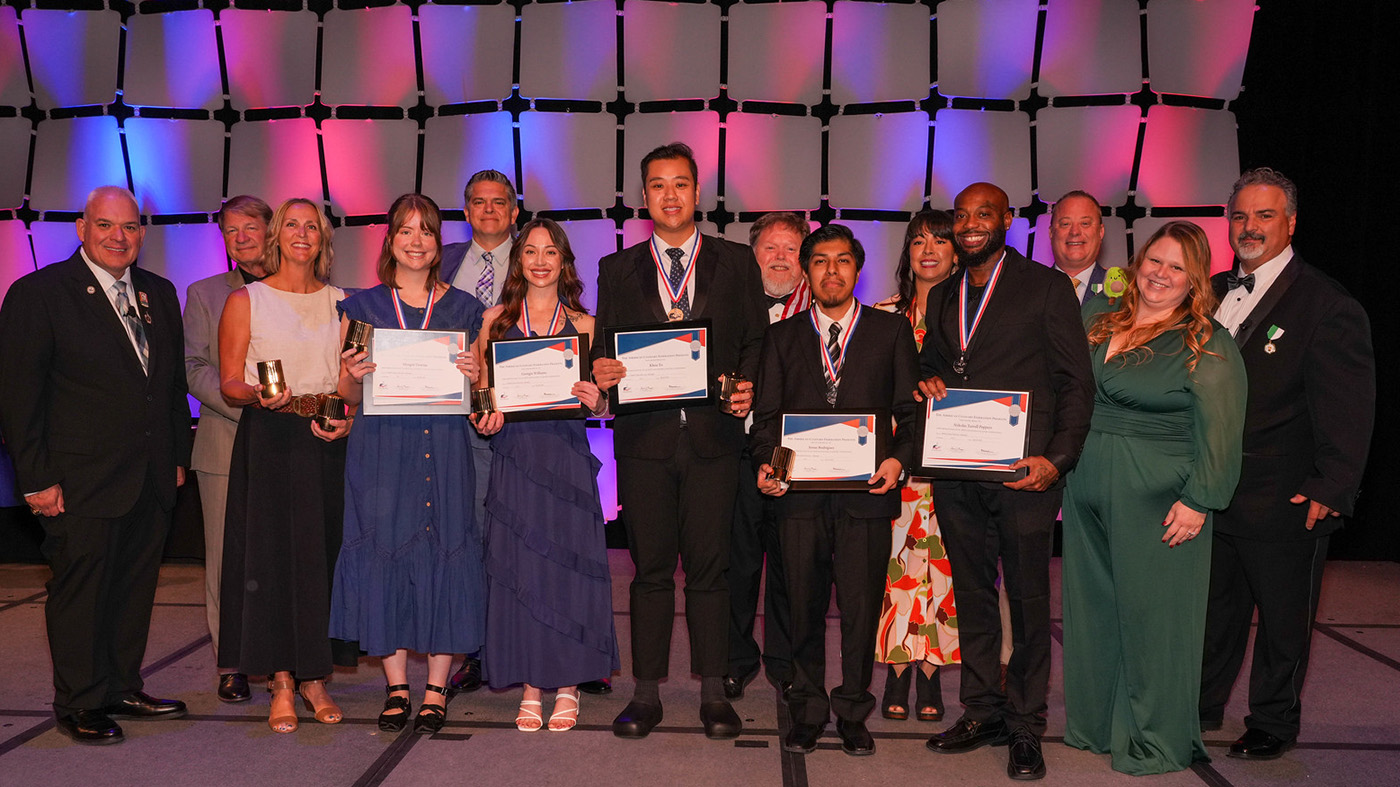 A group of people standing on stage holding certificates