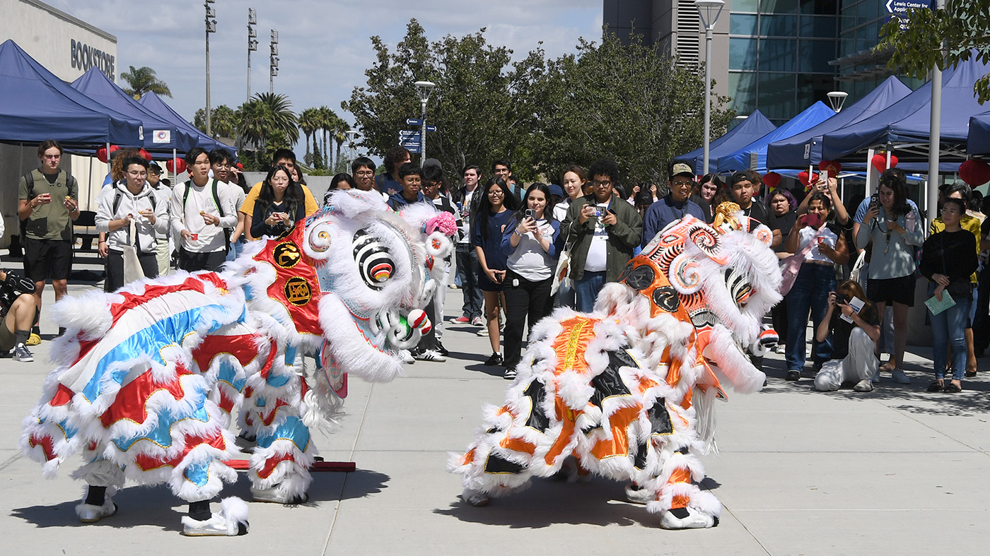 Crowd of people in the background, lion dancers in the foreground