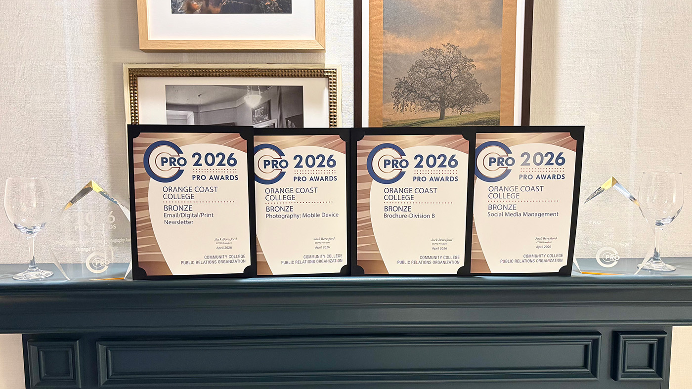 Four 2026 CCPRO Awards bronze certificates and two trophies for Orange Coast College on a mantel with framed art behind.