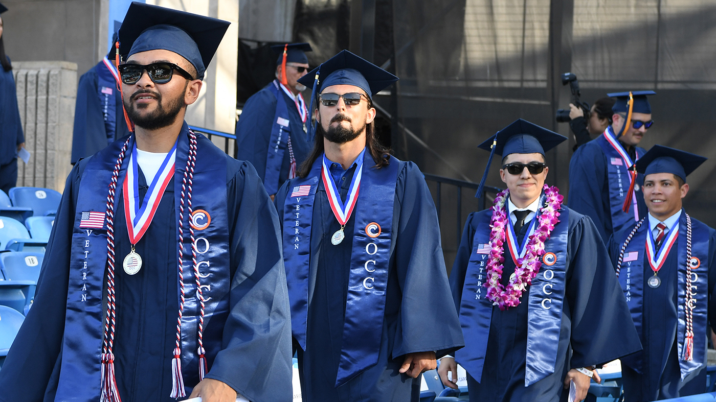 A group of veterans students walking at commencement ceremony.