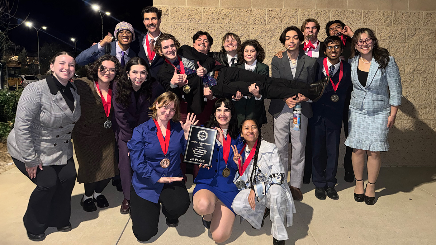 Speech, Debate, and Theater Team standing together holding an award