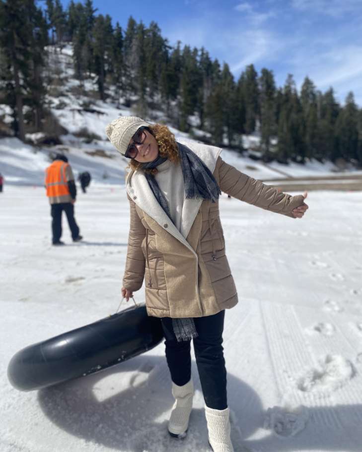 An IEC student holding the black inflatable snow tube