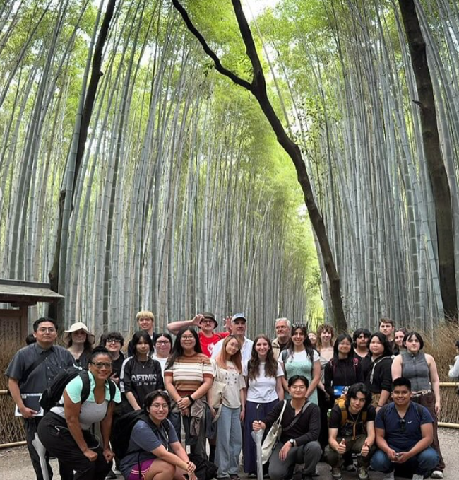 group of students standing in front of the bamboo forest