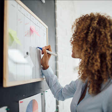 A student writing on a scheduling board.