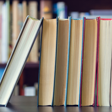 5 books standing up on a table.