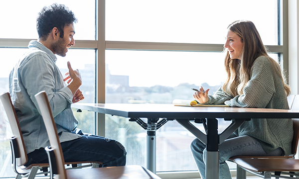 Two people engaged in a conversation at a table.